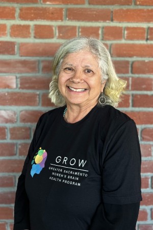 Headshot of Barbara smiling in front red brick wall